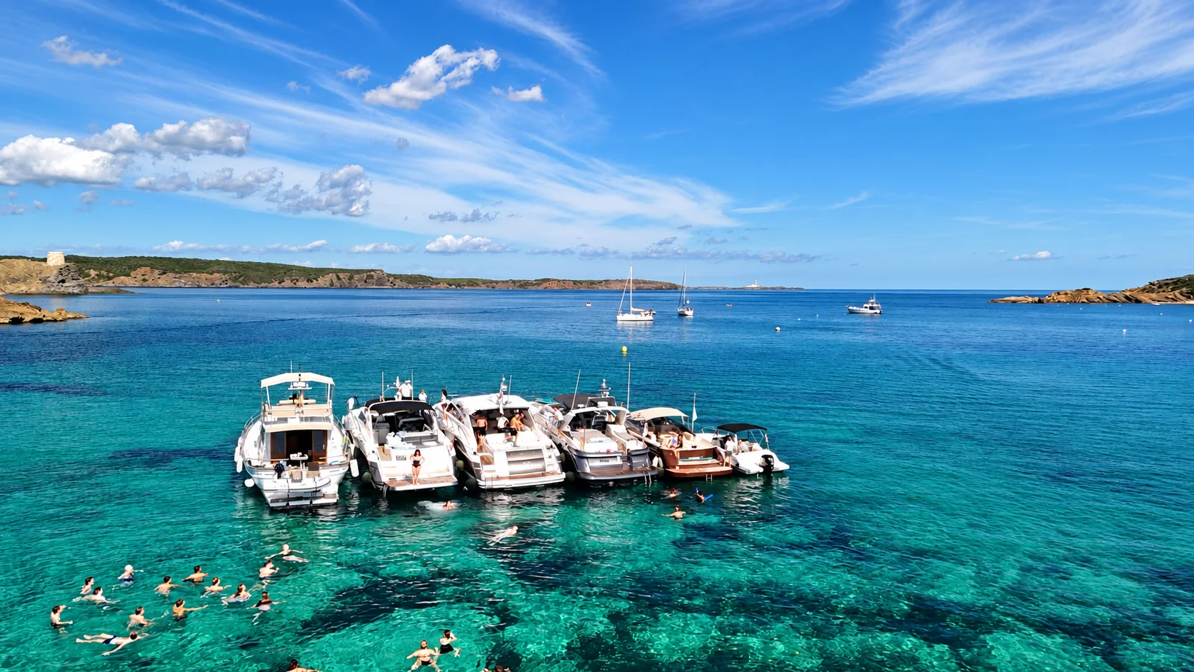 Evento corporativo mit sechs Yachten und rund 50 invitadosn in einer Bucht vor Menorca